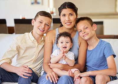 Portrait of a multiracial family at home.Mother with her adoptive sons. Young mother relaxing with her children. Mixed race family relaxing together at home. Boys spending time with their parent `