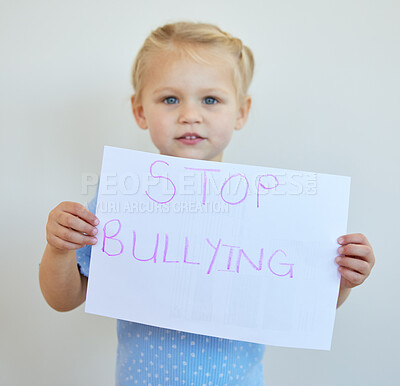 Buy stock photo Little girl protesting against bullying with a sign. Adorable caucasian child standing alone and holding a protest poster against white background. Kid campaigning against bullying