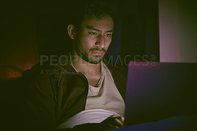 Buy stock photo Indian man hallucinating and feeling paranoid while using his laptop in his messy bedroom at home. Young man feeling stressed and scared. Schizophrenic thinking he's getting hacked through technology