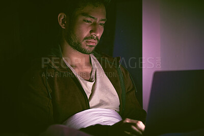 Asian man with mental disorder sitting alone at night and feeling hopeless while searching for a job on a laptop. Mixed race unemployed male feeling depressed and stressed, overwhelmed student