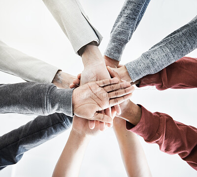 Buy stock photo Low view of Group of businesspeople stacking their hands in support with their colleagues standing in a meeting in an office at work. Businesspeople piling their hands for motivation and success together