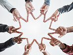 Below hands in circle making a star shape. A group of people putting their fingers together while standing in a huddle outside against a clear and bright sky. Anything is possible with teamwork