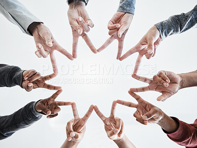 Buy stock photo Below hands in circle making a star shape. A group of people putting their fingers together while standing in a huddle outside against a clear and bright sky. Anything is possible with teamwork