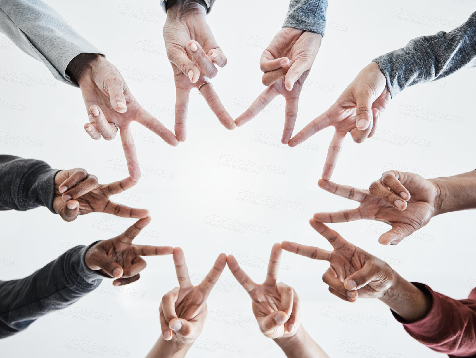 Buy stock photo Below hands in circle making a star shape. A group of people putting their fingers together while standing in a huddle outside against a clear and bright sky. Anything is possible with teamwork