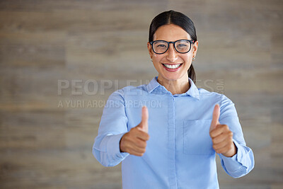Smiling businesswoman showing thumbs up sign with copyspace. Mixed race professional standing alone and using hand gestures to symbol good luck. Hispanic woman wearing glasses endorsing and supporting