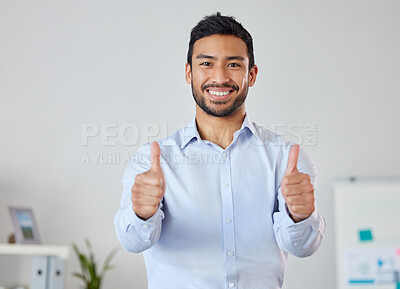 Smiling businessman showing thumbs up sign with copyspace. Portrait of asian professional standing alone and using hand gesture to symbol good luck. Mixed race man endorsing, feeling excited in office