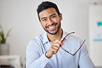 Portrait of a mixed race cheerful businessman removing his glasses while relaxing at his office job . Hispanic man financial advisor smiling while waiting to meet with clients 