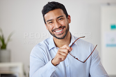Portrait of a mixed race cheerful businessman removing his glasses while relaxing at his office job . Hispanic man financial advisor smiling while waiting to meet with clients