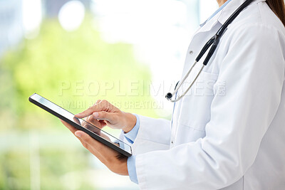 Buy stock photo Closeup of female doctor working on her digital tablet in the office. A unknown mixed race and professional young woman working in a hospital office. Health resources are easy to find online