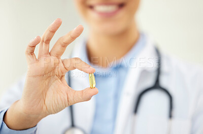 Buy stock photo Closeup shot of an unknown female doctor holding a pill in a hospital