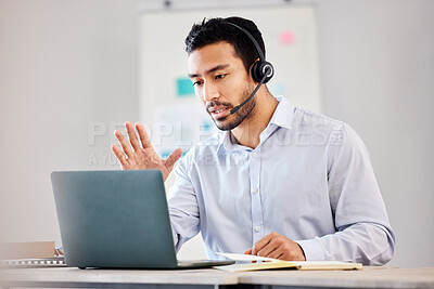 Handsome mixed race male call center agent answering calls working on laptop in an office alone at work. Hispanic Customer service agent on a call, ESL teacher working remote against bright copyspace