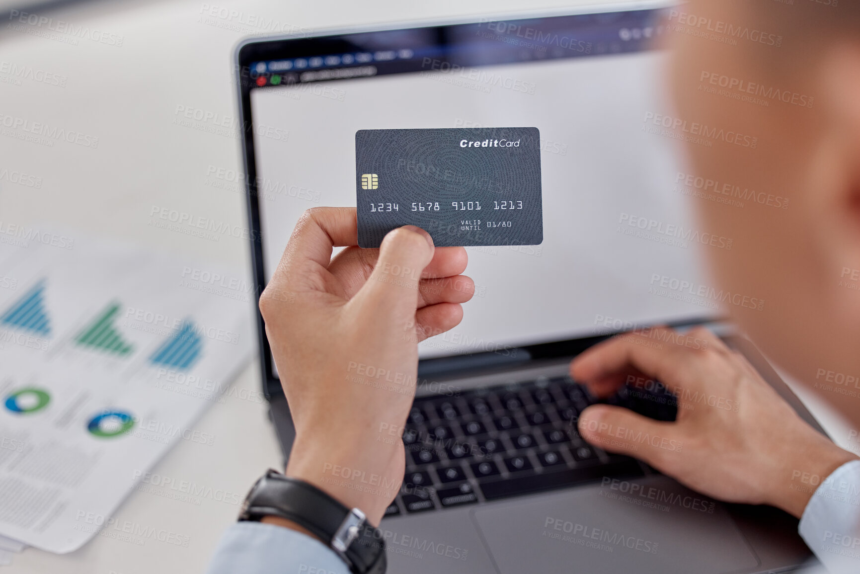 Buy stock photo Above closeup of a business man spending money online with a credit card and laptop in an office. Making purchases with secure banking payment. Planning his budget for bills and e-commerce shopping
