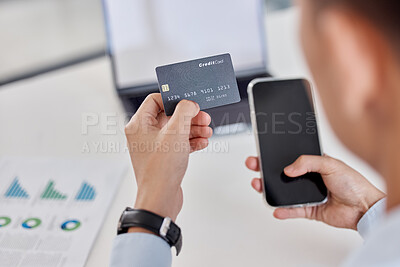 Closeup of one business man spending money online with credit card and cellphone in an office. Making purchase transaction with secure banking payment. Planning budget for bills and ecommerce shopping