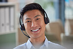Closeup portrait of friendly Asian businessman working in a call center. Financial advisor wearing a headset with microphone. Customer service rep answering calls. Hotline and help desk 