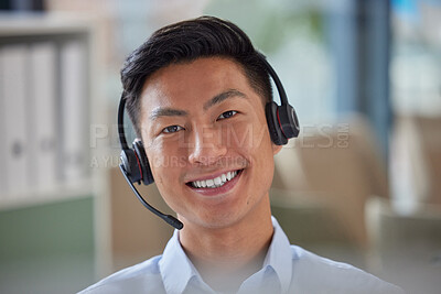 Closeup portrait of friendly Asian businessman working in a call center. Financial advisor wearing a headset with microphone. Customer service rep answering calls. Hotline and help desk