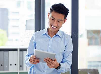 One happy asian business man browsing online on a digital tablet in an office. Smiling guy planning with apps on his wireless smart tech device. Searching the internet for ideas and inspiration