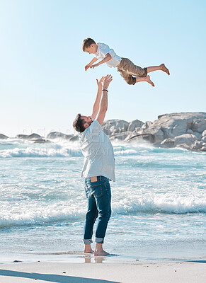 Buy stock photo Single dad playing with son on the beach during the day. Caucasian single father bonding his son and throwing him in the air before catching him. Cute little boy enjoying free time with his parent