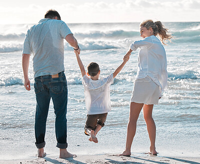 Buy stock photo Cheerful caucasian family walking on the beach. Happy family with tone child only having fun at the beach during summer vacation. Child enjoying a getaway with his parents on bright summer day