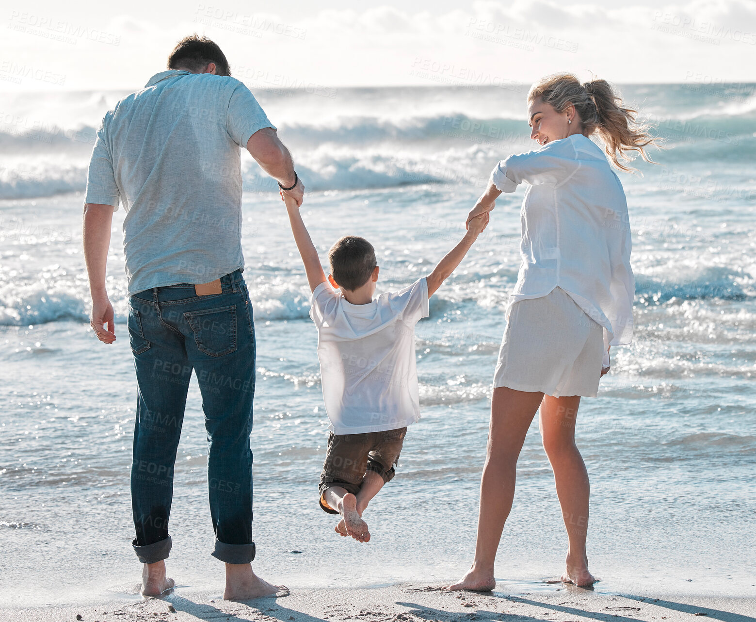 Buy stock photo Cheerful caucasian family walking on the beach. Happy family with tone child only having fun at the beach during summer vacation. Child enjoying a getaway with his parents on bright summer day