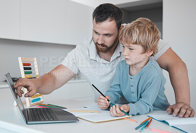 Buy stock photo Young caucasian father helping his son with homework at home. Little boy and dad using a laptop and writing in a notebook together at home. Parent showing a child how to draw at home