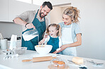 Father pouring milk into bowl for his daughter. Family baking together at home. Little girl baking with her parents. Happy caucasian family bonding in the kitchen.Shocked mother baking with her child