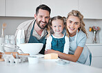 Portrait of happy parents hugging their daughter.Mother and father baking with their daughter. Caucasian family bonding in the kitchen. Smiling parents embracing their little girl.