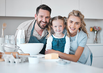 Buy stock photo Portrait of happy parents hugging their daughter.Mother and father baking with their daughter. Caucasian family bonding in the kitchen. Smiling parents embracing their little girl.