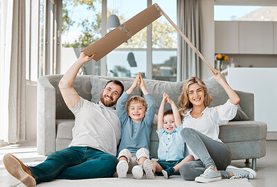 Buy stock photo Smiling couple with little kids sitting and making symbolic roof with cardboard over children. Caucasian brothers protected by parents. Mother and father covering their sons with family care insurance