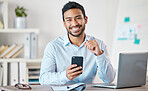 Portrait of a young handsome happy mixed race businessman using social media on his phone while working alone on a laptop in an office at work. One hispanic male boss smiling using a cellphone at work