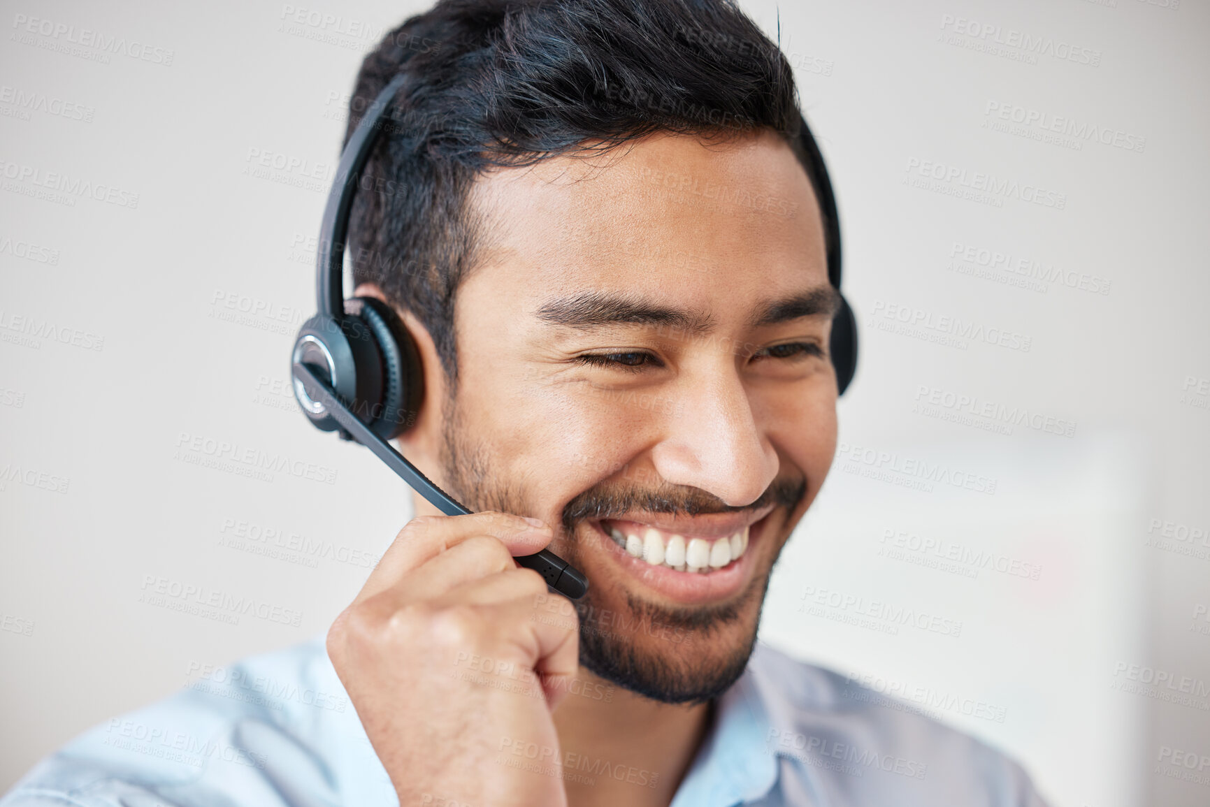 Buy stock photo Closeup of smiling mixed race call centre agent smiling while wearing headset. Young male customer service representative using wireless headset and consulting clients online