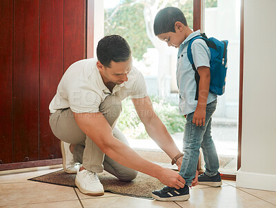 Buy stock photo Father and son adjusting shoes at home, getting ready for first day of school. Dad dressing his cute little boy at the door, before leaving the house in the morning. Child care, family and education