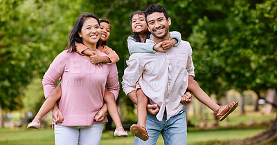 Young happy mixed race family relaxing and walking together in a park. Loving hispanic parents giving their daughters a piggyback in nature. Sisters bonding with their mom and dad outside in a garden