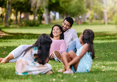 Buy stock photo Portrait of happy asian couple lying together on grass. Kids playing while watching their loving parents spending time together at the park