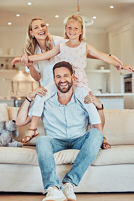 Buy stock photo Portrait of excited little playful girl sitting on father's shoulders and holding mother's hands while pretending to fly at home. Happy caucasian parents enjoying fun quality time with daughter