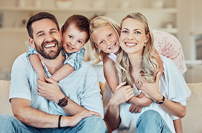 Buy stock photo Portrait of smiling caucasian family relaxing together on a sofa at home. Carefree playful little son and daughter hugging arms around loving parents. Happy kids bonding with mom and dad