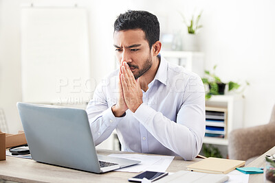 Buy stock photo Young focused mixed race businessman working alone on a laptop in an office at work. Serious hispanic male boss thinking while reading an email on a laptop. Man looking at his laptop screen