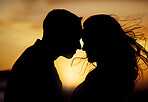 Silhouette couple enjoying romantic moment with their foreheads touching against sunset background. Unknown boyfriend and girlfriend feeling in love while bonding outside. Man and woman gently hugging