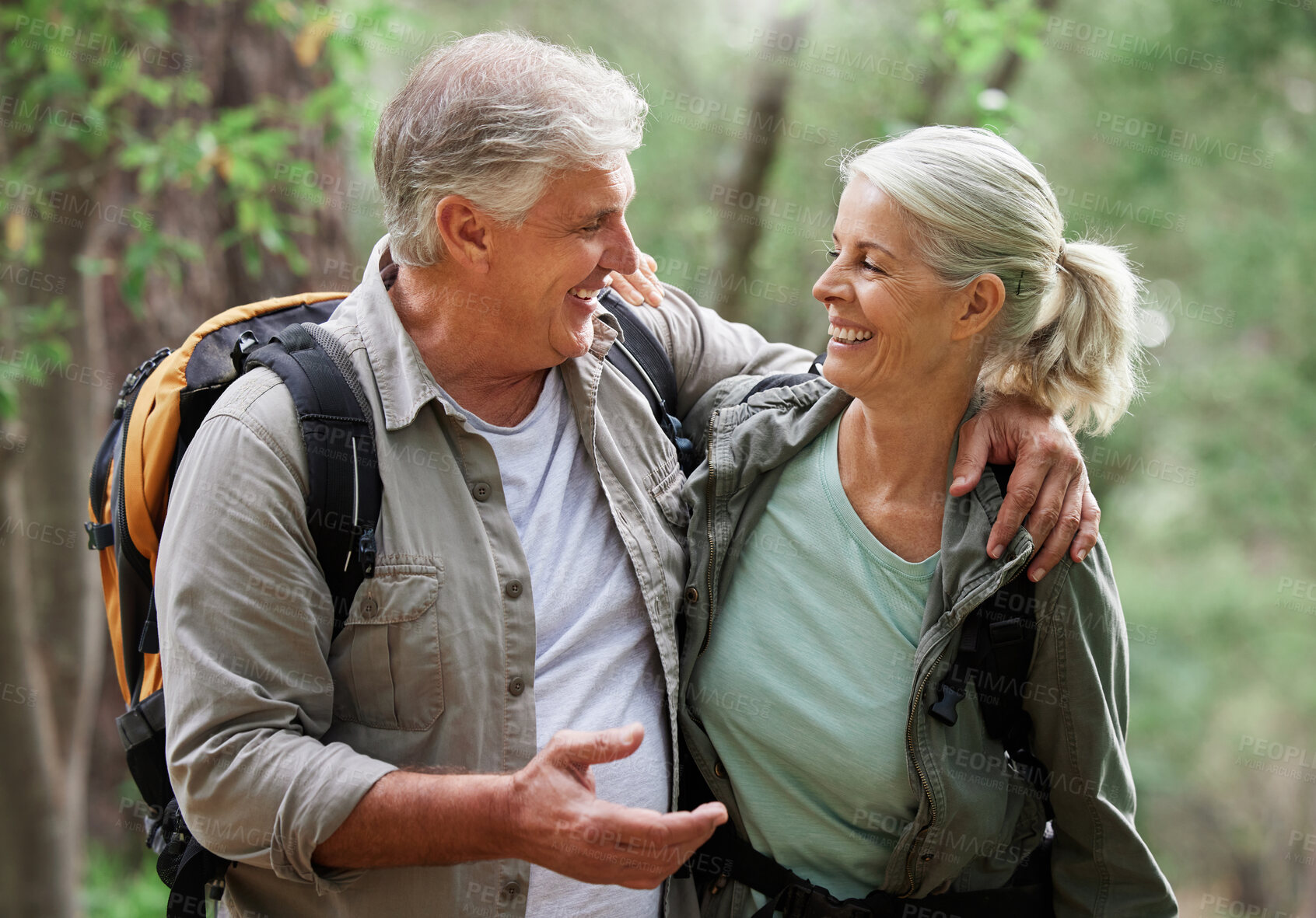 Buy stock photo Talking, hiking and happy senior couple on nature adventure in forest, woods and mountain for exercise. Fitness, retirement and elderly man and woman smile, in conversation and trekking for wellness