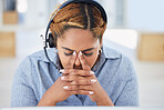 Stressed young mixed race female call centre agent getting a headache while working in office. Consultant making mistakes and struggling with difficult customers when operating a support helpdesk