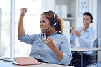 One happy young mixed race female call centre telemarketing agent cheering with joy and punching the air with fists while working in an office. Excited businesswoman celebrating successful sales and reaching targets to win