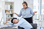 Close up of young asian businessman feeling tired and sleeping on the desk of a call center in a office while his hispanic female colleague looks confused and upset. Male wearing wireless headset suffering from burnout