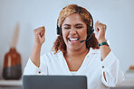 Young happy and excited mixed race businesswoman cheering in support while working on a laptop and wearing a headset alone in an office at work. One hispanic female boss smiling while celebrating success and victory