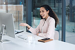 A smiling mixed race call centre agent looking happy and positive while wearing a headset. Female customer service worker using headset and consult with clients online while sitting at office desk 