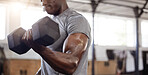 Unknown african american athlete lifting dumbbell during bicep curl arm workout in gym. Strong, fit, active black man training with weight in health and sports club. Weightlifting exercise routine