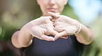 Close up of female athlete interlocked hands while stretching her arms during workout in nature on a sunny day. Fit sportswoman doing warmup exercise before her run in nature