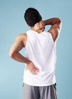 Rearview young mixed race man wearing a vest in studio isolated against a blue background. Unrecognizable male athlete suffering from back pain or ache. He\'s picked up an injury during exercise