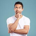 Handsome young mixed race man looking thoughtful with his hand on his chin and looking away while standing in studio isolated against a blue background. Hispanic male thinking about a bright idea