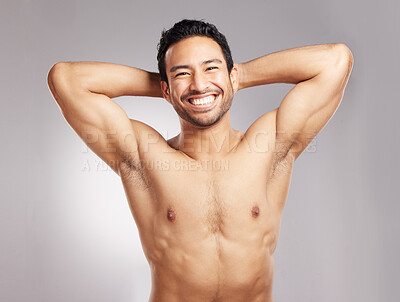 Buy stock photo Handsome young mixed race man shirtless in studio isolated against a grey background. Hispanic well groomed male looking confident and happy with his daily skincare regime. Firm and healthy skin