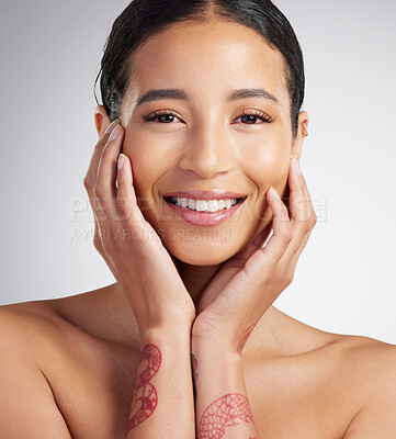 Buy stock photo Portrait of a beautiful mixed race woman touching smooth soft skin in a studio. Hispanic model with healthy natural glowing skin looking confident against grey copyspace while doing routine skincare