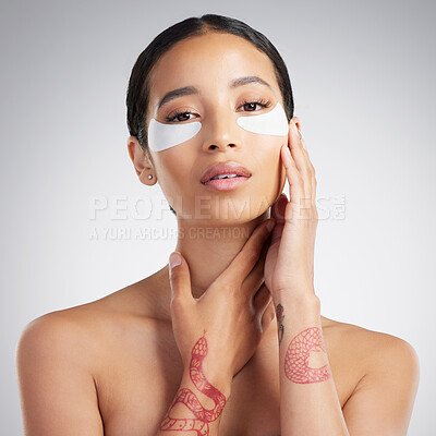 Buy stock photo Studio Portrait of a beautiful mixed race woman wearing under eye patches. Hispanic model with glowing skin using hydrating treatment against a grey copyspace background